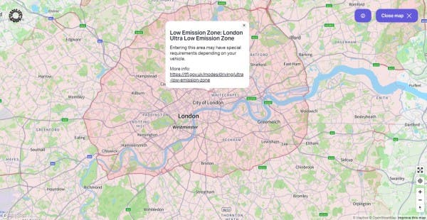 Interactive map view from Vanlifezone highlighting the Low Emission Zone in London, with the Ultra Low Emission Zone clearly marked in pink overlay. Key areas such as the City of London, Westminster, Greenwich, and surrounding neighborhoods like Brixton, Chiswick, and Edgware are visible. The map includes river details, road networks like the A40 and M1, and green spaces throughout. An information pop-up provides details about the emission zone and a link for more information. Navigation tools and a 'Close map' button are included, along with Mapbox and OpenStreetMap credits.