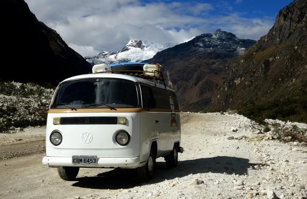 @viajayreite's Volkswagen T2 Kombi parked on a rugged mountain road in the Andes with snow-capped peaks in the background, highlighting Belu and Lucho's adventurous slow travel lifestyle.